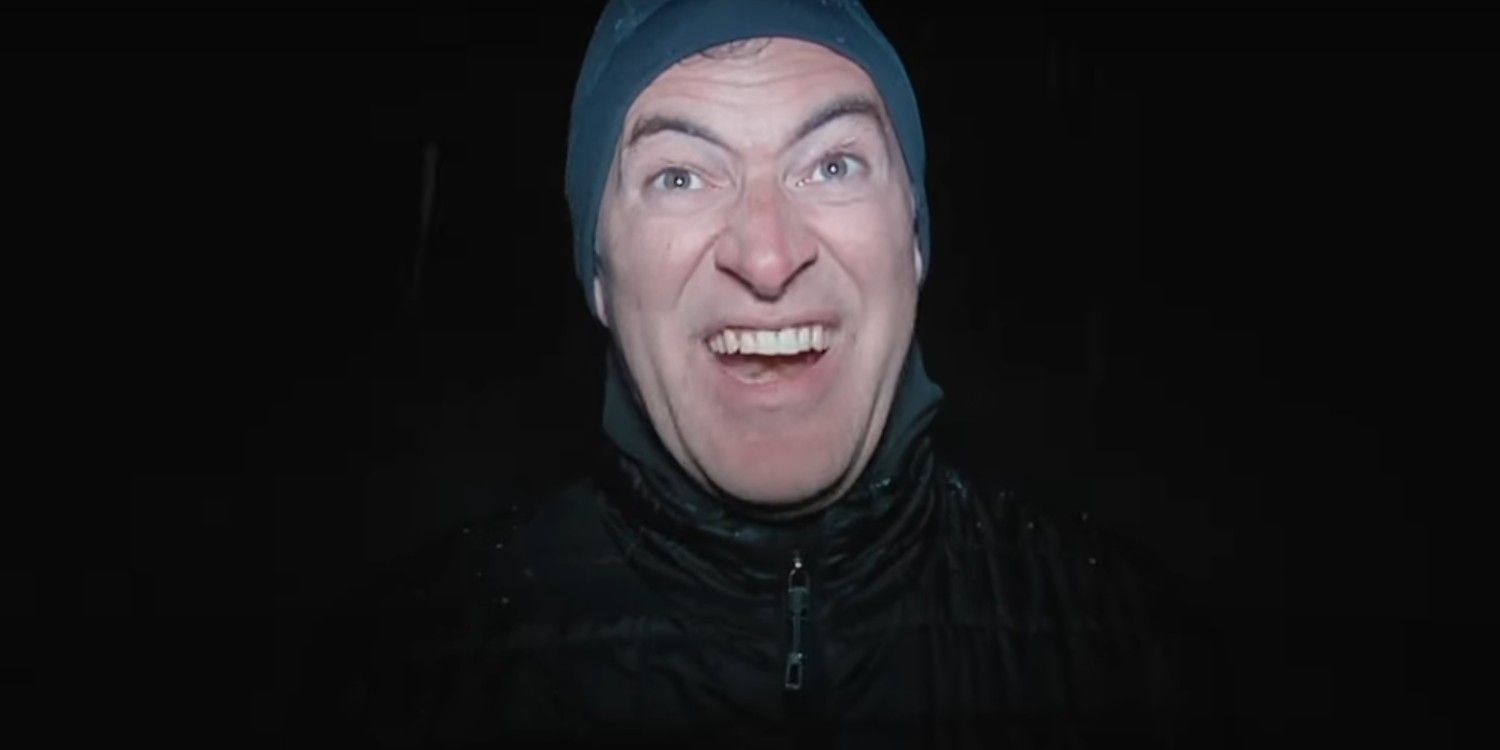 mark duplass serial killer in winter gear standing in a darkened enviornment in the creep tapes